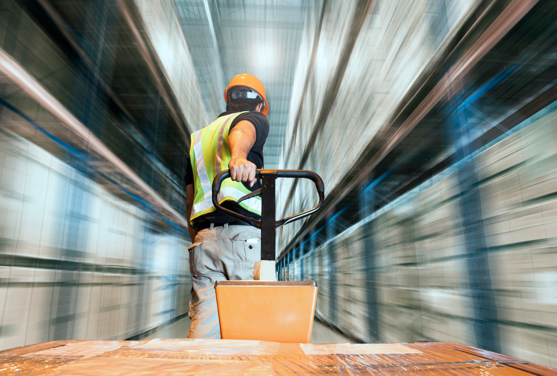 Motion burry of warehouse, warehouse worker using hand pallet truck unloading pallet goods at warehouse storage. Cargo & warehouse shipping, Shipment, Logistics and transportation.